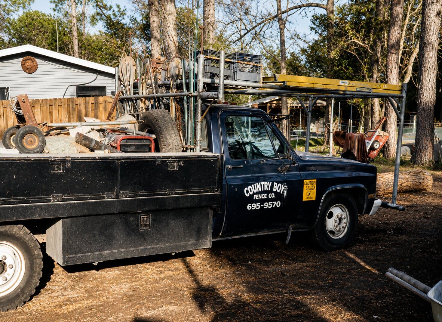 An early Country Boy Fence navy flatbed loaded with materials.